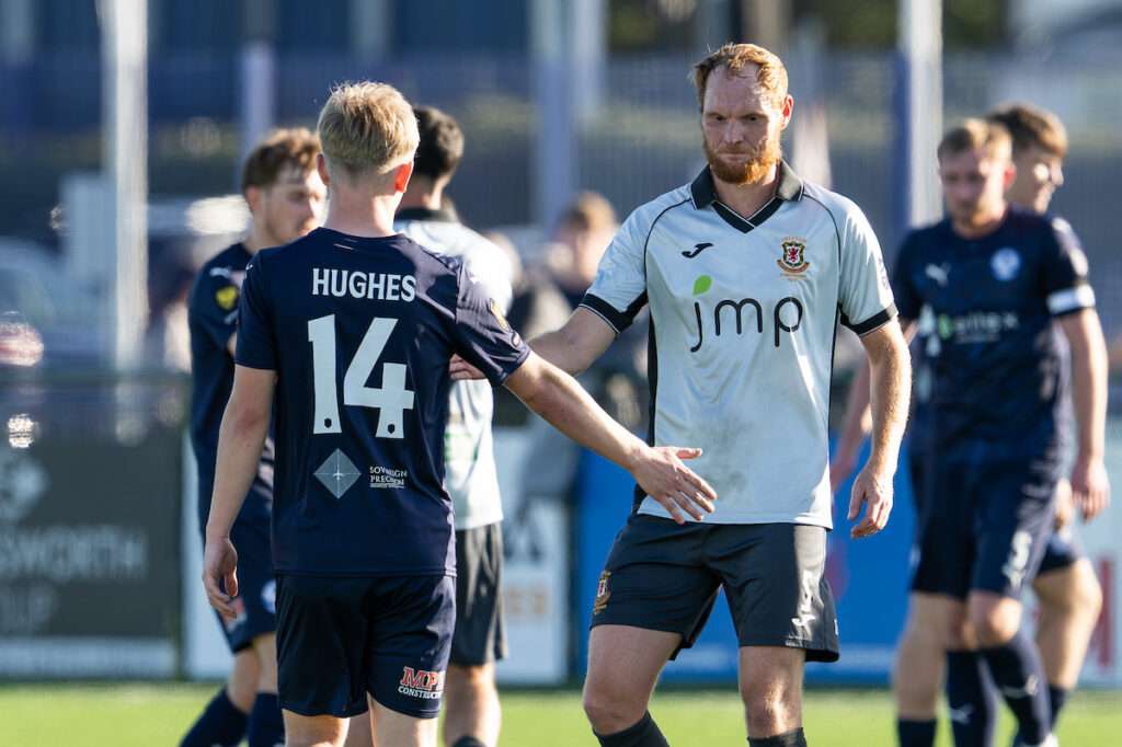 Trefelin's Shaun Macdonald and James Hughes of Airbus UK Broughton shake hands at the end of the Novira Cymru Premier game between Airbus UK Broughton and Trefelin BGC at The Hollingsworth Group Stadium in Broughton.