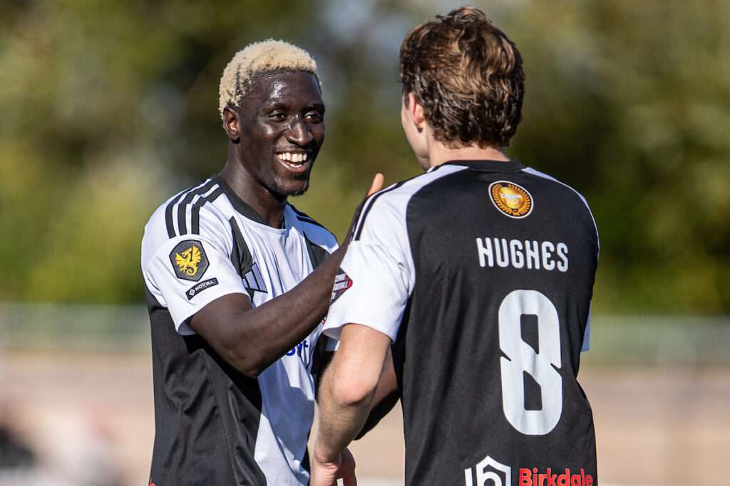 Lassana Mendes of Flint Town United makes it 3-0 during the 2026-27 Novira Cymru Premier match between Flint Town United and Ammanford at Essity Stadium, Flint, Wales