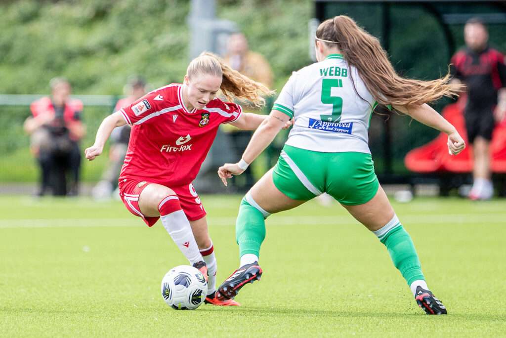Wrexham's Katie Barker takes on Tiggy Webb of The New Saints during the 2026-27 Genero Adran Premier match between Wrexham and The New Saints at The Rock, Wrexham, Wales