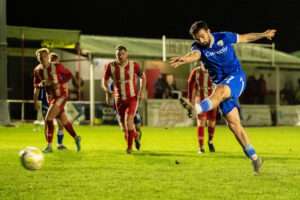Jordan Williams of TNS makes it 6-1 from the penalty spot during the 2026-27 Novira Cymru Premier match between Holywell Town and The New Saints at Halkyn Road, Holywell, Wales