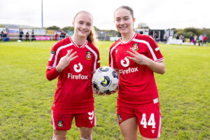 Wrexham's Katie Barker & Faye Knox celebrate their hat tricks during the Genero Adran Premier match between Swansea City & Wrexham at the Garden Village Park, Swansea, Wales