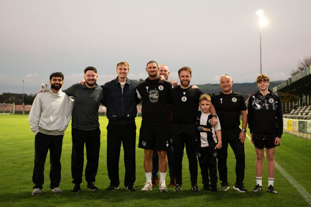 Alfie Indra and Ellis Platten with Ammanford AFC members of staff