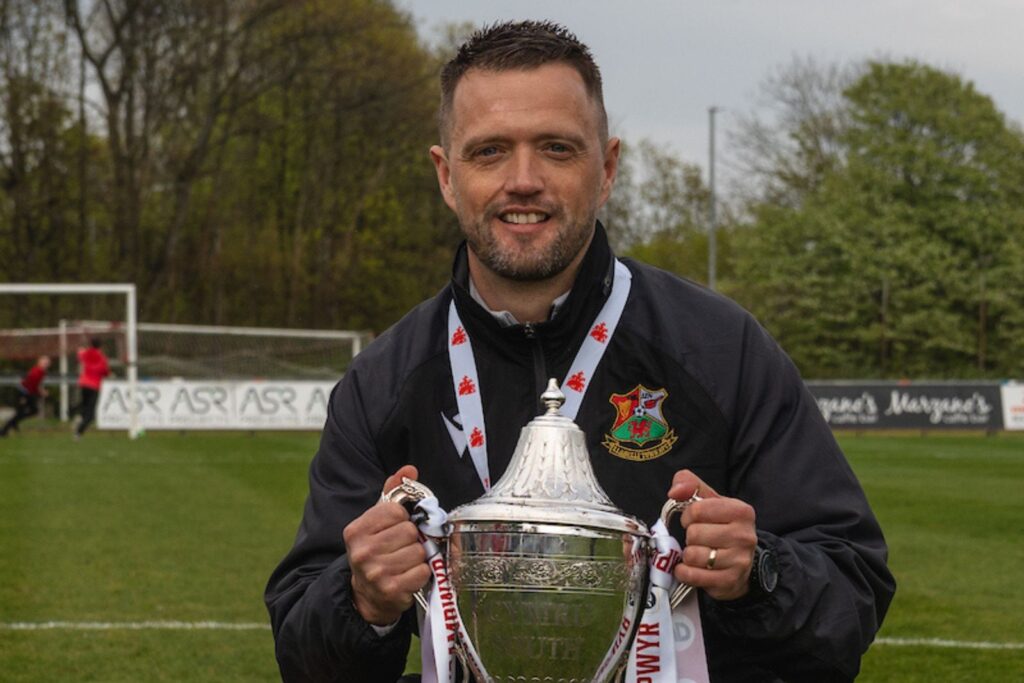 Llanelli Town manager Lee John poses with the Cymru South trophy